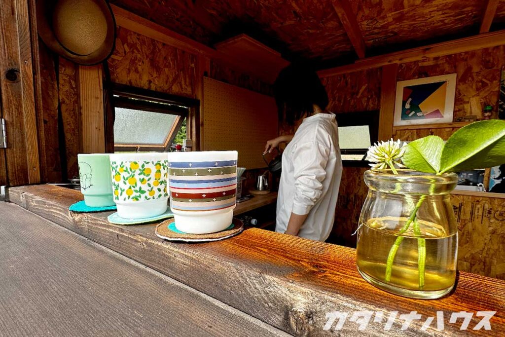 まめさんコーヒーの山小屋カフェで並ぶマグカップとシロツメクサの飾り