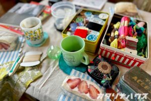 ダーニング部の活動テーブルに並ぶ刺繍糸や手芸道具、コーヒーとフルーツサンド