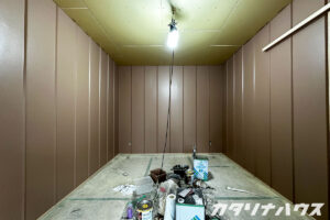 ピンクを帯びたブラウンに塗装された部屋の内装リノベーション作業風景