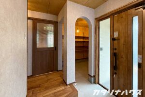 玄関ホールから土間収納を望む。アーチ状の開口が特徴的なリノベーション住宅の玄関まわり