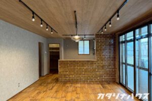 中古住宅をフルリノベーションした開放感あるLDK。木目の天井と床、タイル張りのキッチンカウンターが印象的