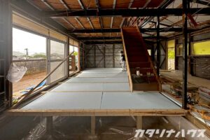 住宅の床下に断熱材を敷設し、木下地を整えたリノベーション中の室内全景。快適な室温環境を実現するための工事