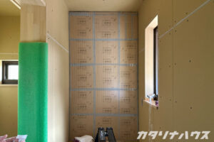 住宅リノベ工事でタイルを施工した壁。小ぶりのタイルはバラバラにならないようにシールでまとめられている。