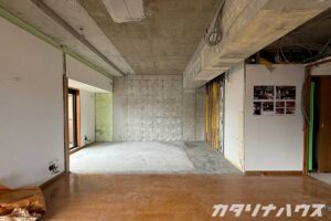 解体が完了し、コンクリートの構造が露わになったマンションの一室。床は一部が剥がされ、壁には配線が残っている。