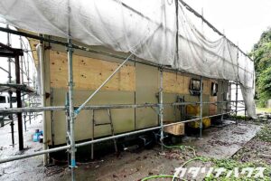裏手の外壁部分で構造用合板による補修作業が進行中の現場写真