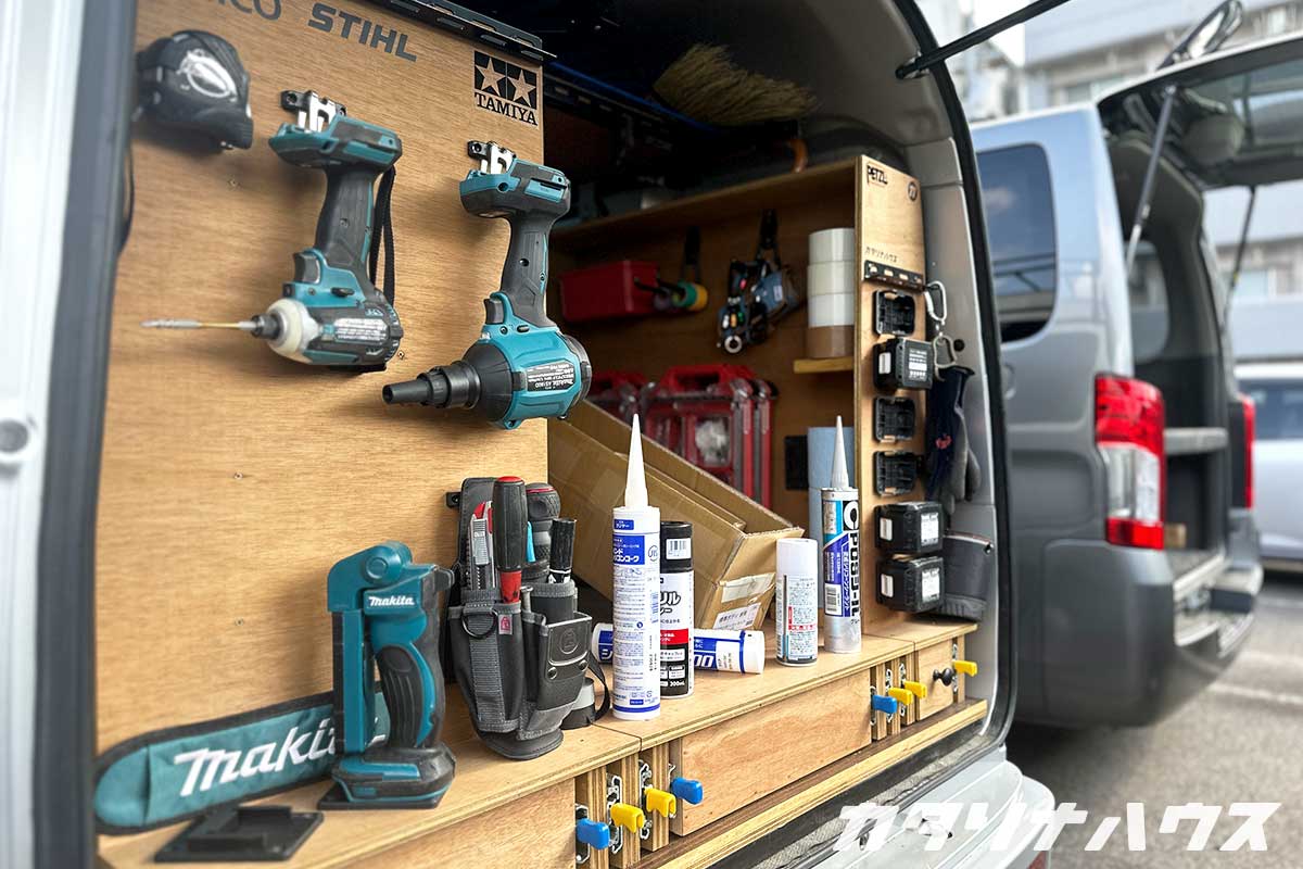 軽バンの荷室にDIYで工具収納を設置した様子。電動ドライバーや接着剤が整理されて並ぶ作業車内の収納棚。