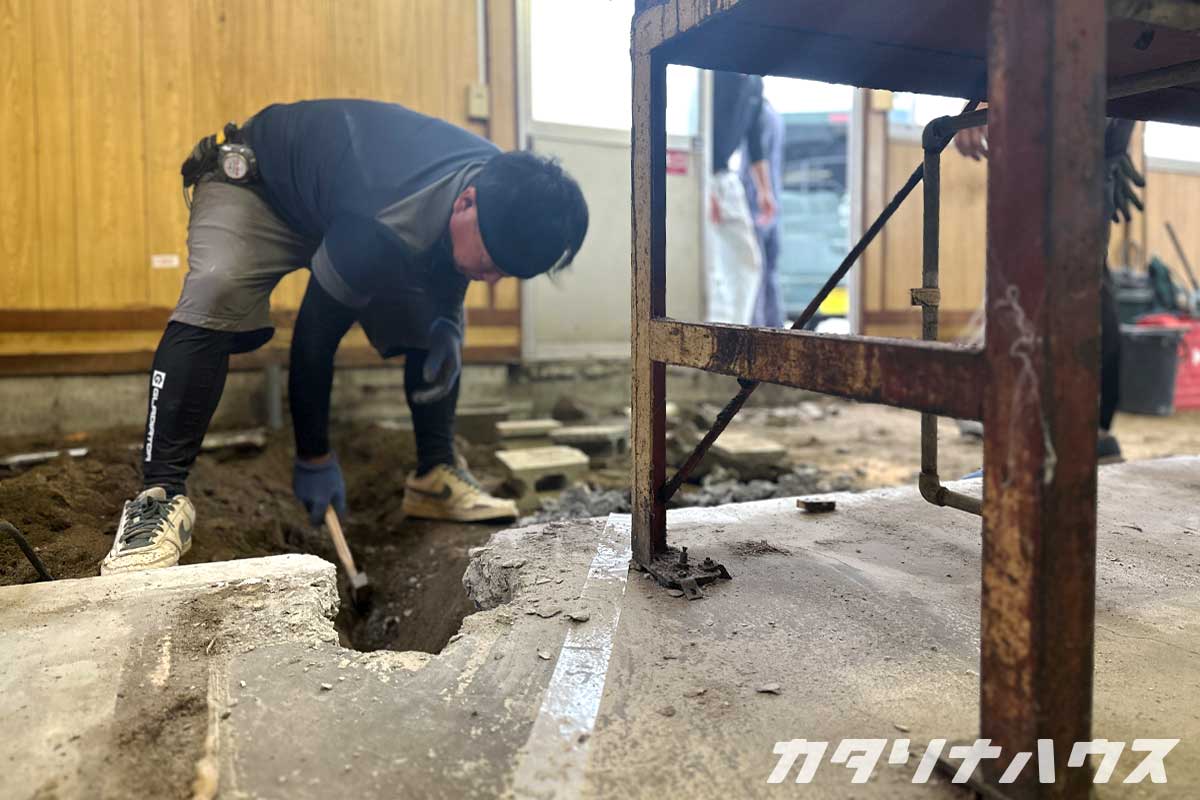 店舗改装のため床下の古い配管を撤去し新しい給排水工事の準備をする作業員