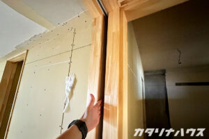 引き込み建具。扉が引き込まれるスキマに手を入れて確認している様子。