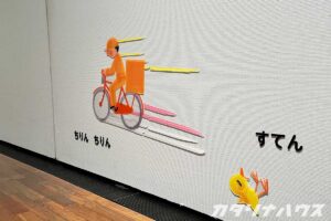 自転車に乗った子どもがさっそうと移動する様子とひよこが転んでいる屋内展示