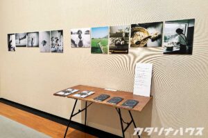 カメラマンが撮影した風景写真や人物写真の展示。写真が掲載されている冊子が展示の前に置かれている。