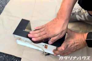 既存の黒い塗装を落とすため、照明器具を丁寧に研磨する作業中