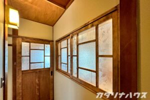 古い建具と再利用した照明が調和した廊下の完成した内装