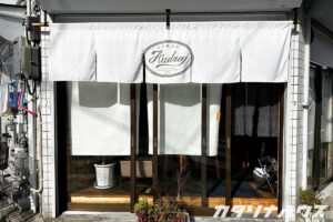 二重に重なる白暖簾を店の外から見た様子。