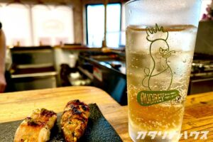 愛媛県内唯一の鶏肉専門店Audreyの店内で頂く焼き鳥とジンジャーエール。鶏のイラストが入ったグラスと焼き鳥。