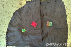 黒い布にカラフルな糸で施されたダーニング。穴はすっかり隠れています。