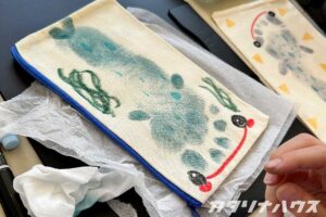 青色の足型アートを生かしてジンベイザメの絵を施したポーチ。