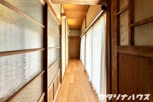 廊下にならぶ掃き出し窓にはレースカーテンが付けられている。