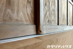 木製引き戸のディテール。長年使われた木目と滑らかな床の質感が調和する