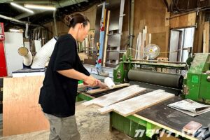 カットされたパーツにボンドを塗る女性職人
