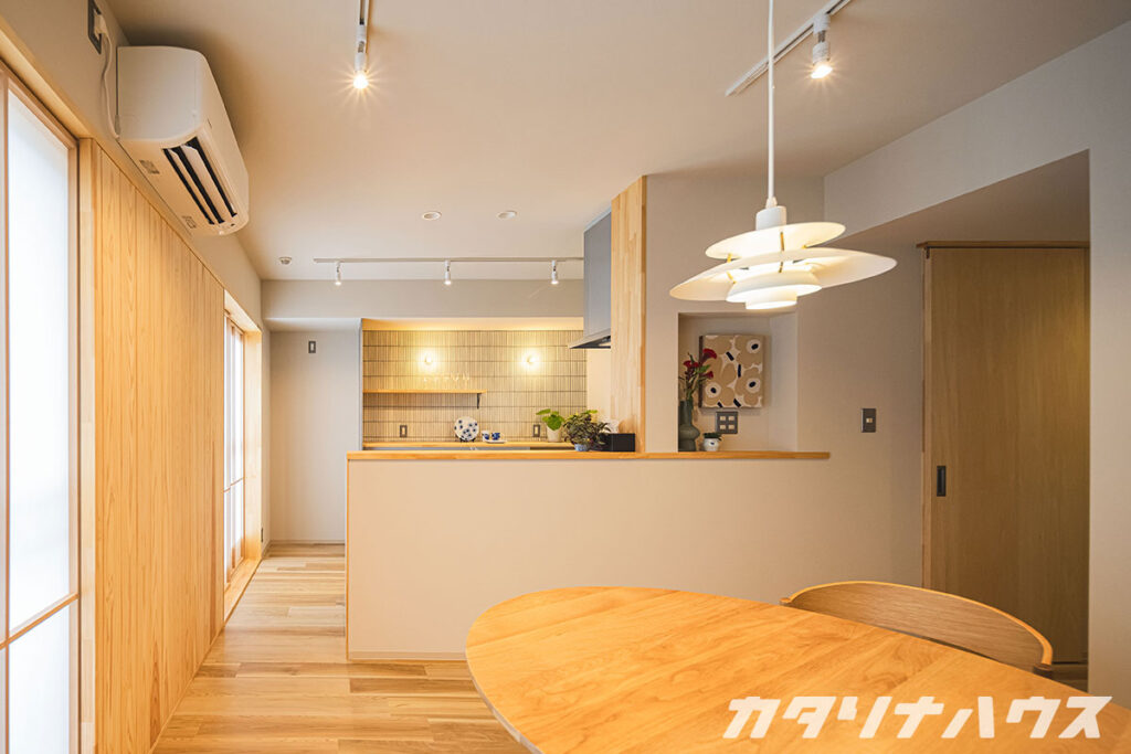 明るい木色が温かい雰囲気のLDK。対面キッチンの奥にはタイルが貼られている。