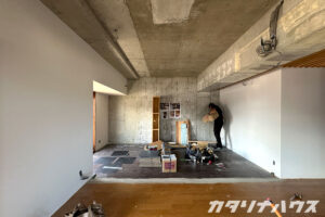 両壁は白いクロスが貼られ、正面の壁と天井はコンクリートそのままの味わいを残した工事後の室内。