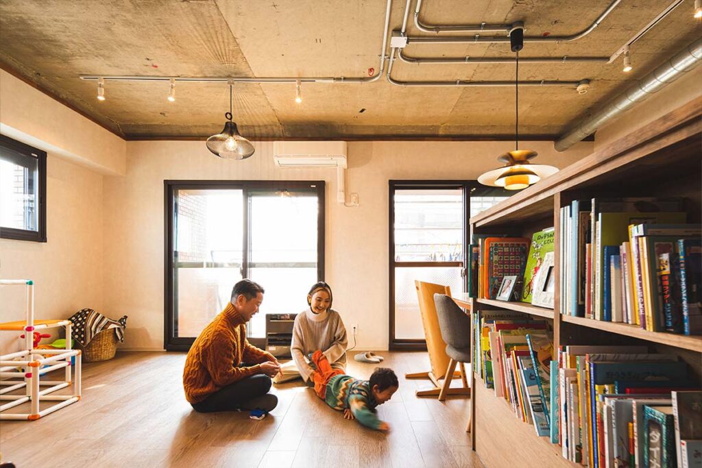 リノベーションした中古マンションのLDKで家族団らんしている様子。