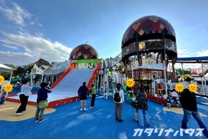 巨大なすべり台と丸い展望ドームが特徴の大型複合遊具ゾーン。子どもが多く集まる人気エリアで、カラフルなすべり台や遊具が並ぶ公園の広場。