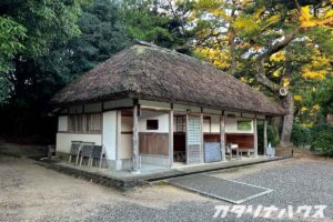 厚い茅で葺かれた伝統的な日本家屋。木材と白壁の組み合わせが美しく、自然の中に佇む歴史ある茅葺きの建物