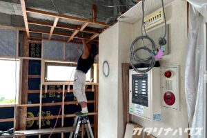 脚立に上りリノベーション工事を行う職人さん。