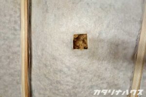 切り込みの入った不織布から粉砕された木の繊維が見える。ぎっしり詰めるので暑さ・寒さ対策にも効果を発揮する。