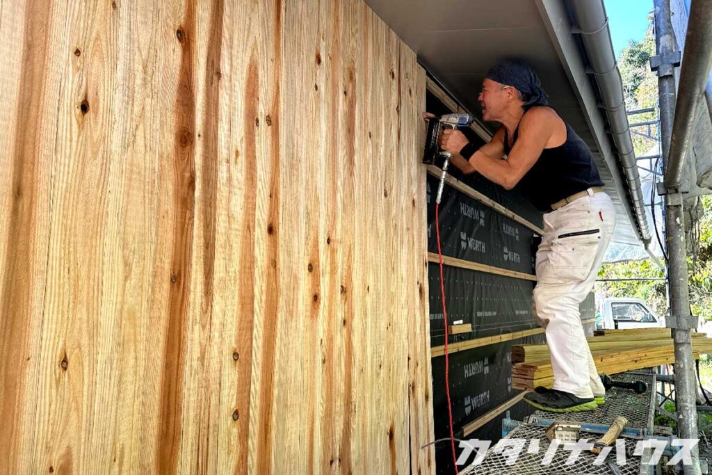 外壁を貼る大工。愛媛県産の杉を使用。