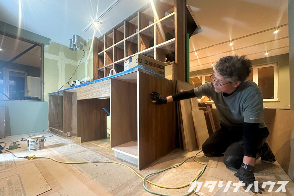 造作キッチンの塗装を行う男性スタッフ