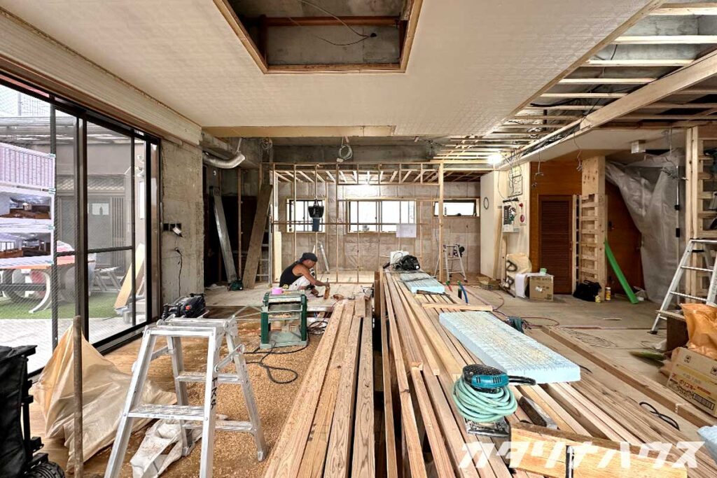 松山市のリノベーション工事現場。解体後の室内で構造を確認しながら木下地を組む大工の作業風景