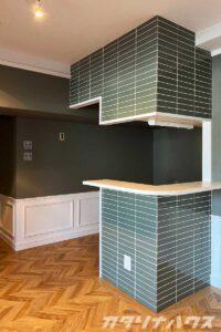 キッチンのコーナーに貼られた青緑の釉薬タイル