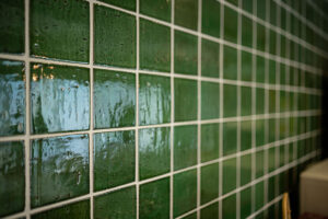 濃い緑の釉薬タイルに白目地のインテリア