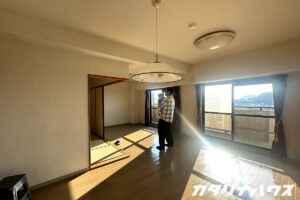 マンションリノベーション前のLDKで部屋を見学する父子