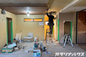 天井にクロスを貼る前のパテ処理を行う職人さん