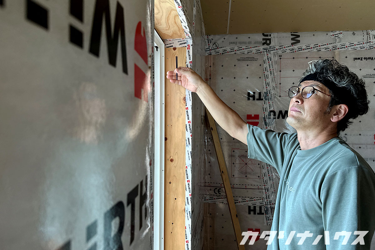 蚊取り線香の煙を使って窓回りの気密性を確かめるスタッフ。