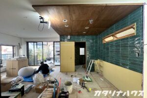 青緑色のつやつやしたタイルが貼られた下がり天井がポイントのキッチン