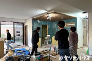 緑色のタイルが貼られた台所を見学するご夫婦