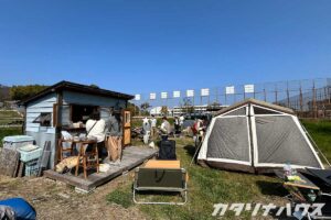 青空に芝生が映える広場でテントとストーブを設置したイベント