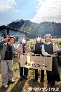 まめさんコーヒーののれんを持ったイベント出店者たち