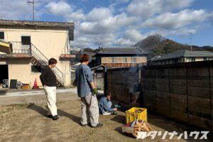 家庭用焼却炉にブロアーで風を送る子供とそれを見守る大人二人