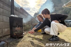 焼却炉で焼き芋を焼きながらマシュマロを焼くスタッフ