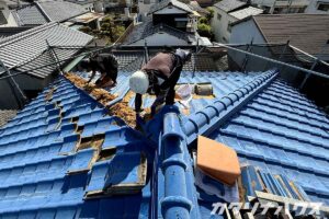 屋根の瓦を一枚ずつ外している作業の様子。耐震工事の工程