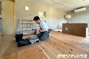 杉フローリングの上で建具調整の作業をする職人さん