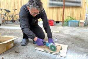 造作洗面台に使うグリーンのタイルを職人がカットしている様子