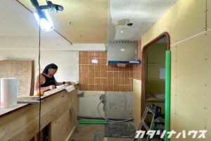 オレンジ色のタイルを貼ったリノベーション中のキッチン壁