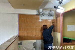 キッチンの壁に貼られたオレンジ色のタイルが見えてきた様子