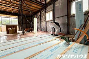 中古住宅リノベーションで床下に断熱材を敷き詰める様子